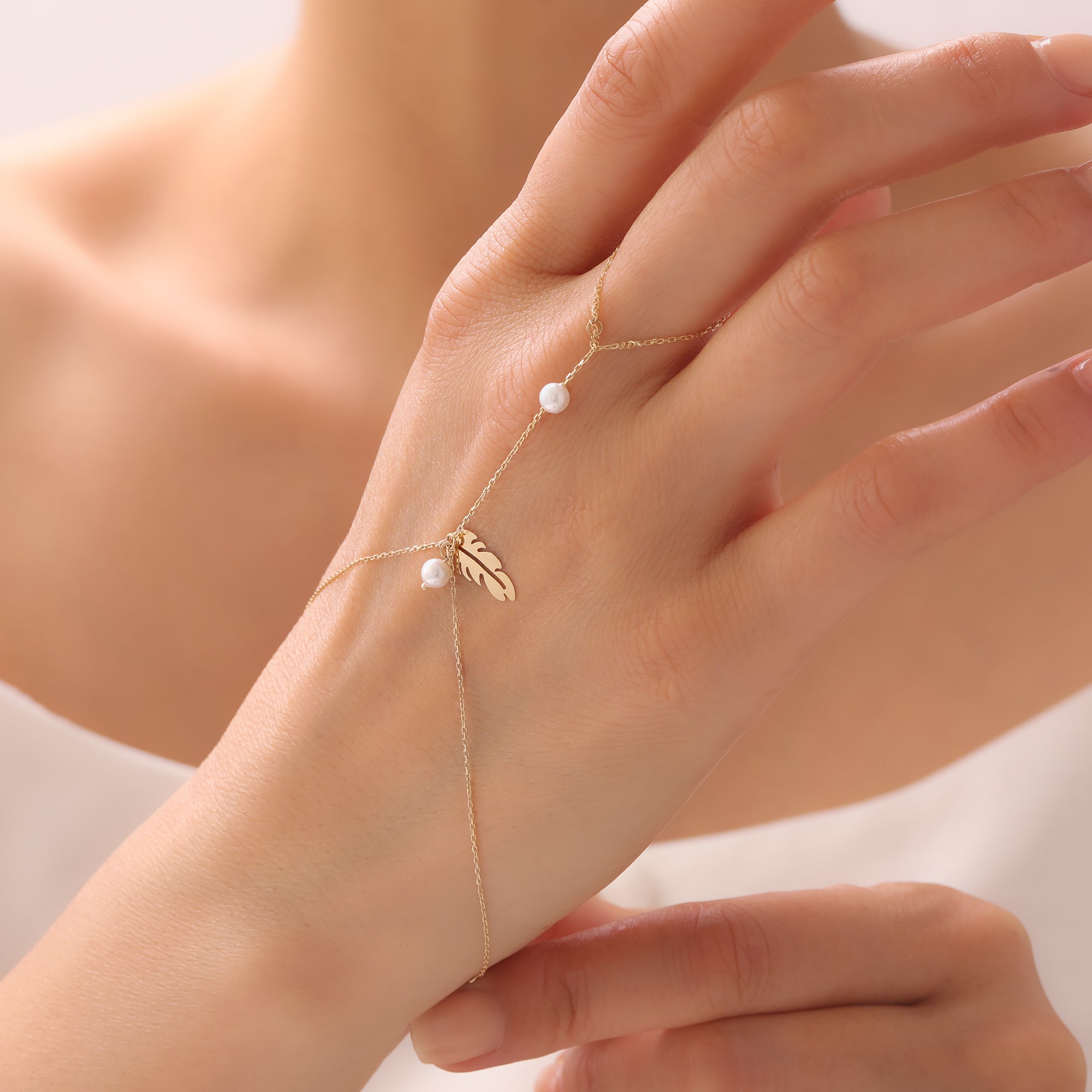 PERLENVOGEL-FEDER HANDKETTE | 14K GOLD